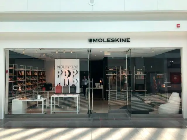 A store front with a sign that says moleskine on it