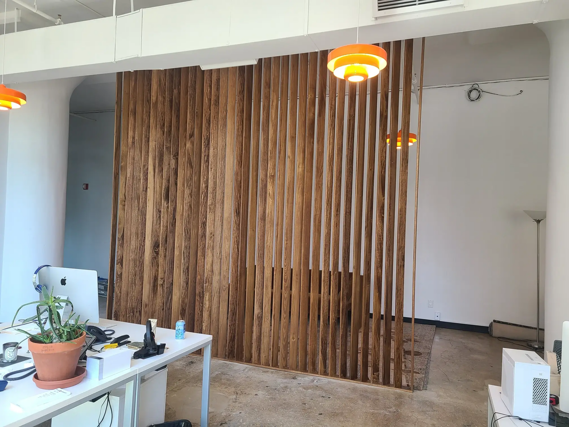 A room with a wooden wall and a desk with a computer on it