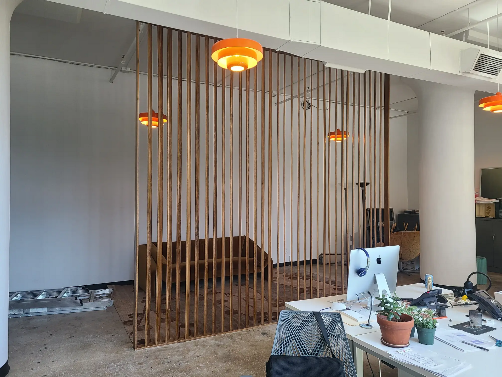 A room with a wooden divider and a computer on a desk.