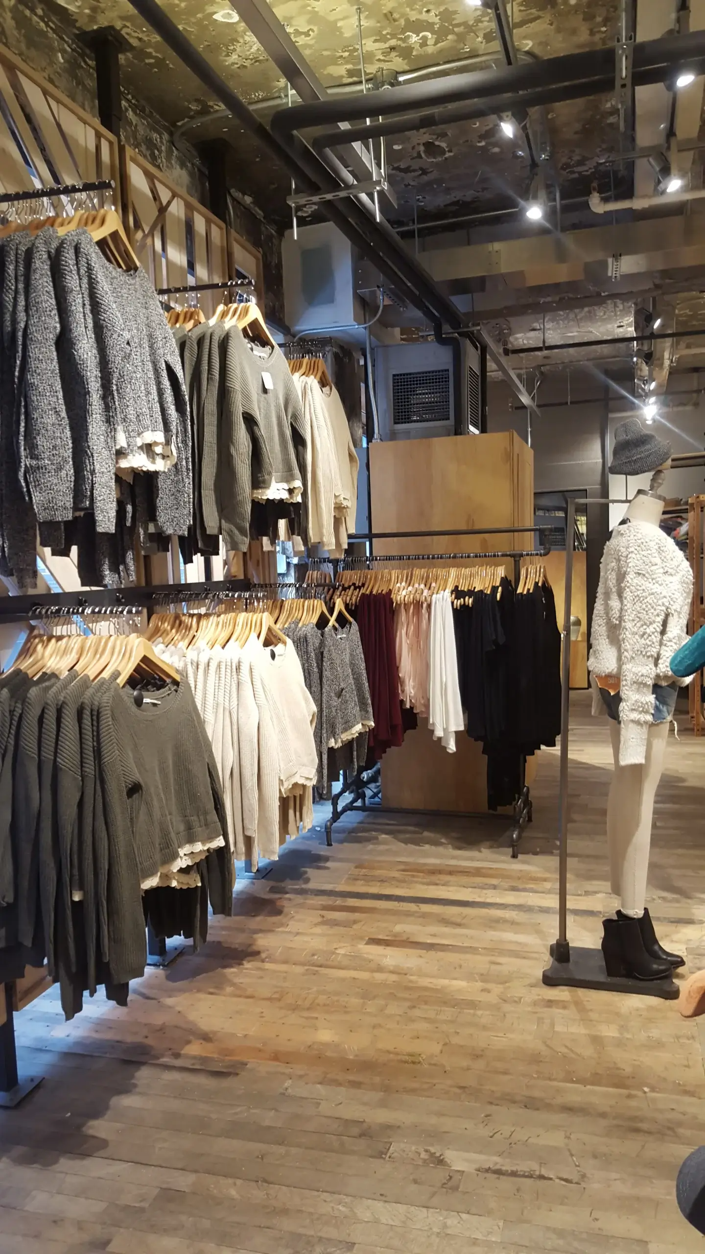 A store filled with lots of clothes and a mannequin.