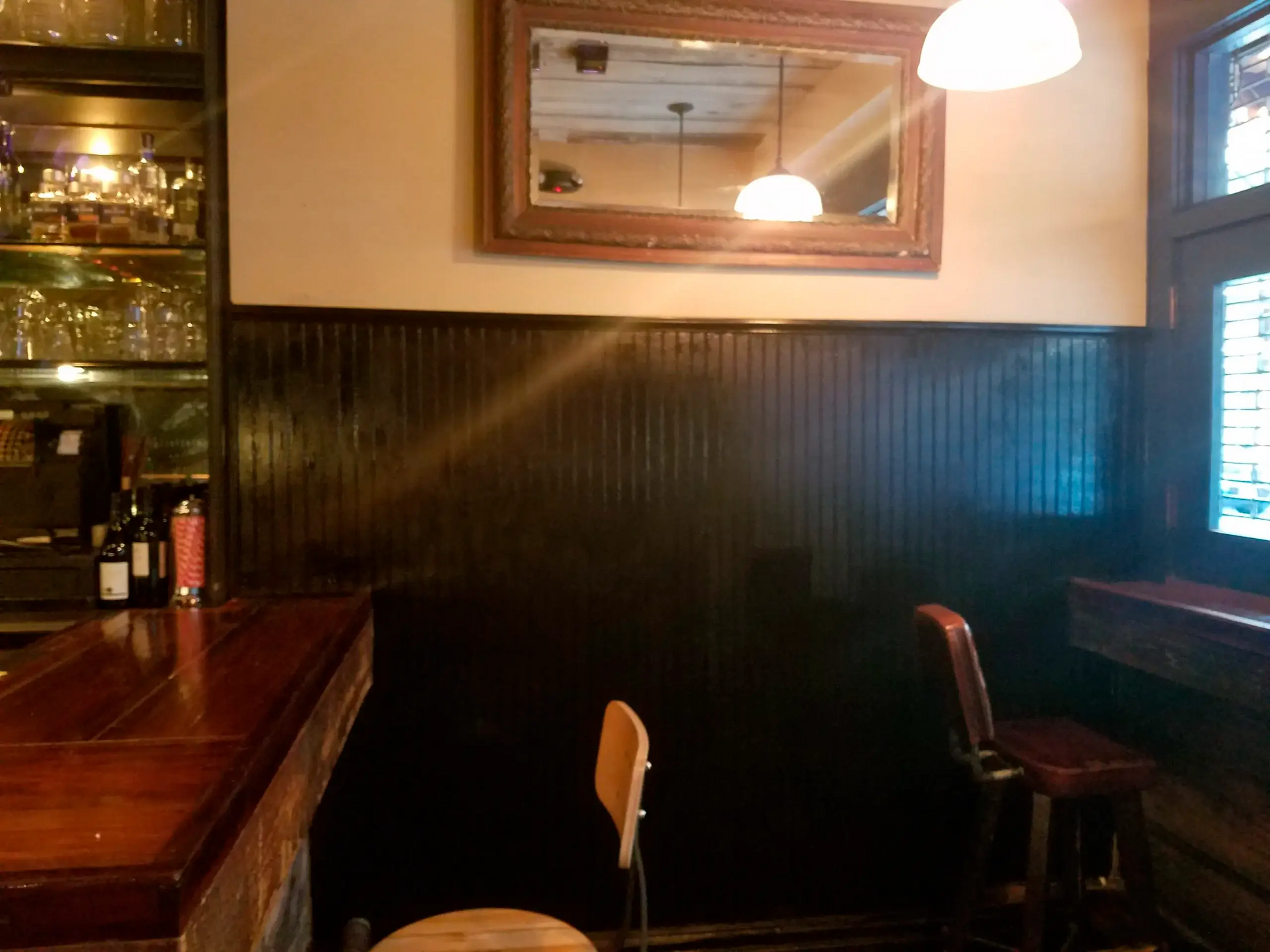 A corner of a restaurant with a mirror on the wall
