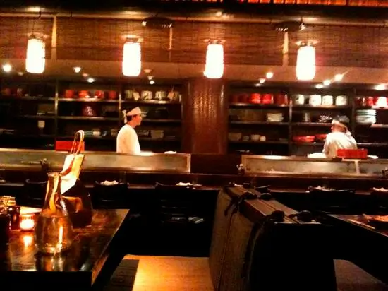 A man in a white shirt is standing at a counter in a restaurant
