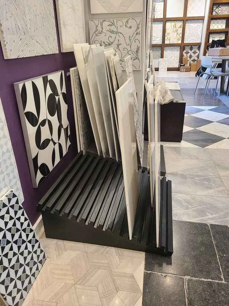 A display of tiles in a store with a purple wall.