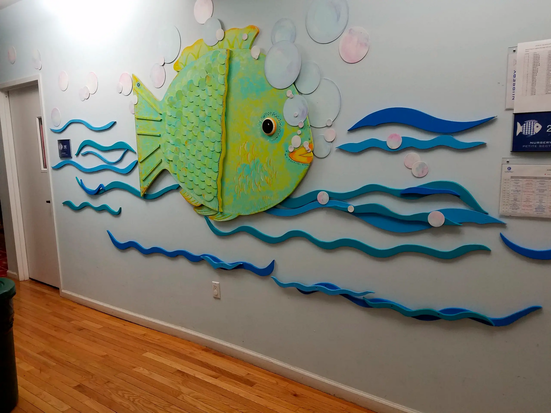 A hallway with a painting of a fish on the wall