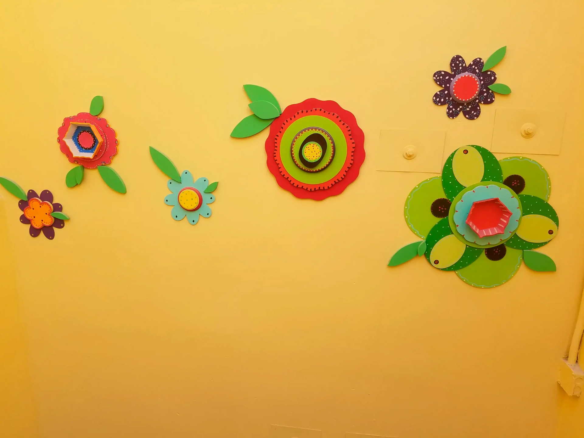 A yellow wall with colorful flowers on it