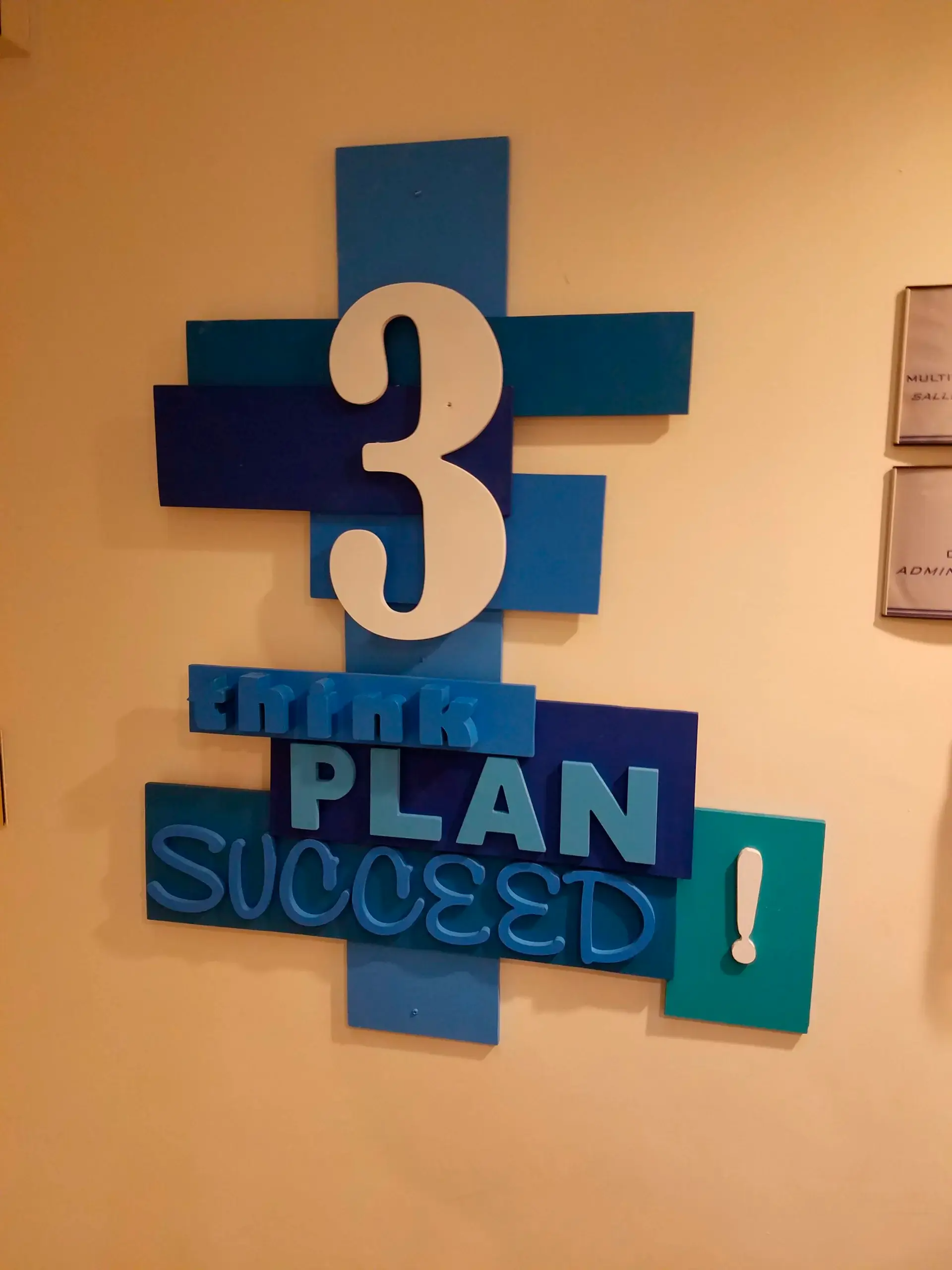A sign on a wall that says 3 plan succeed