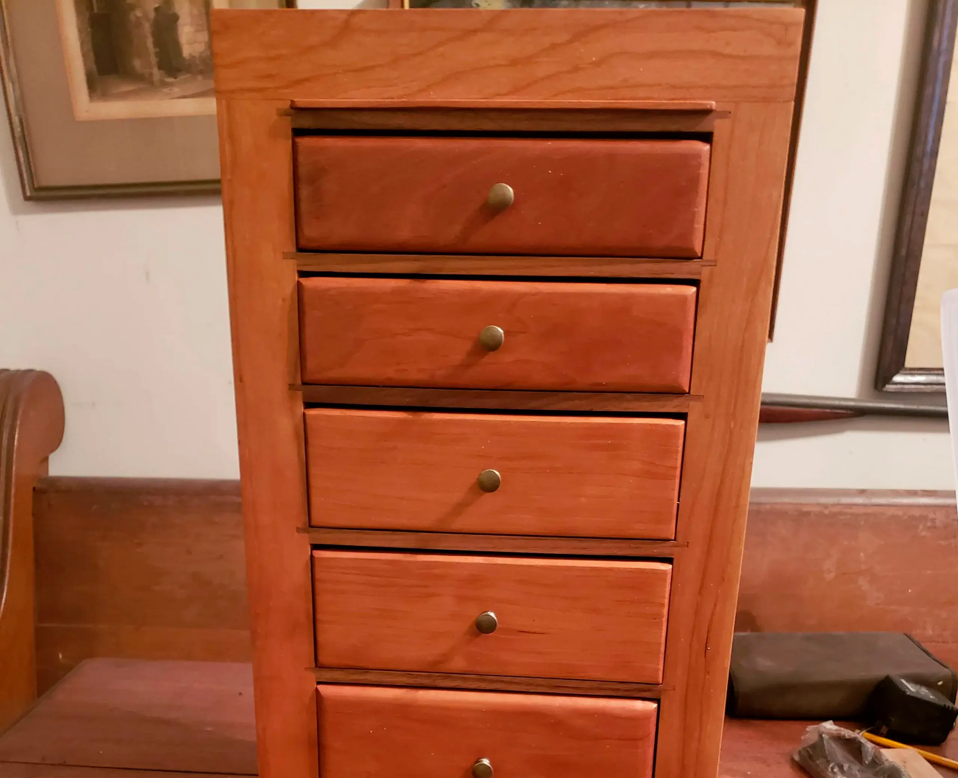 A wooden chest of drawers is sitting on a table