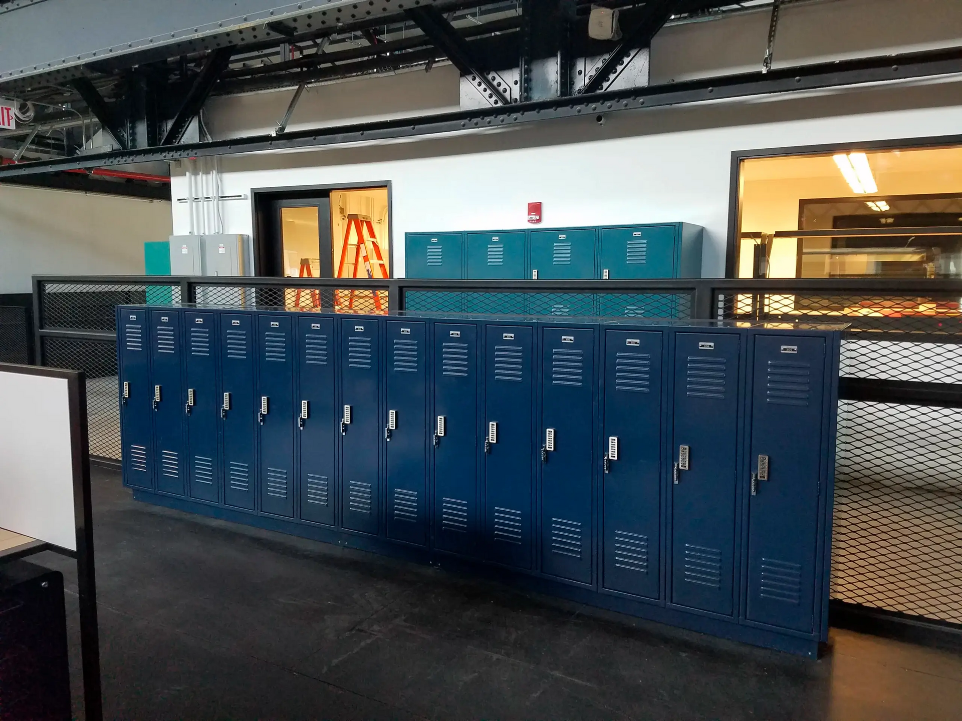 A row of blue lockers are lined up in a room.