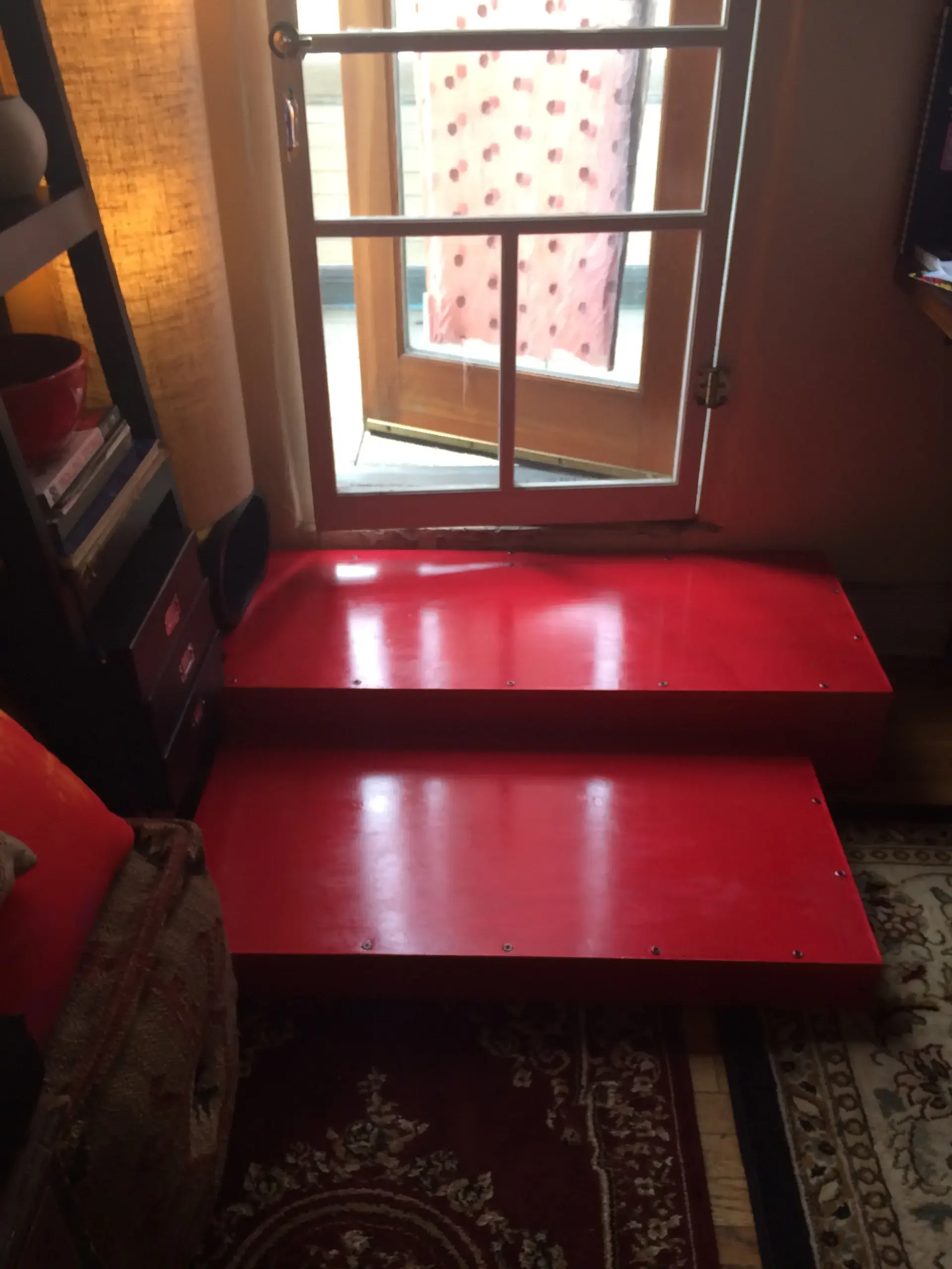 A red staircase leading to a door in a room