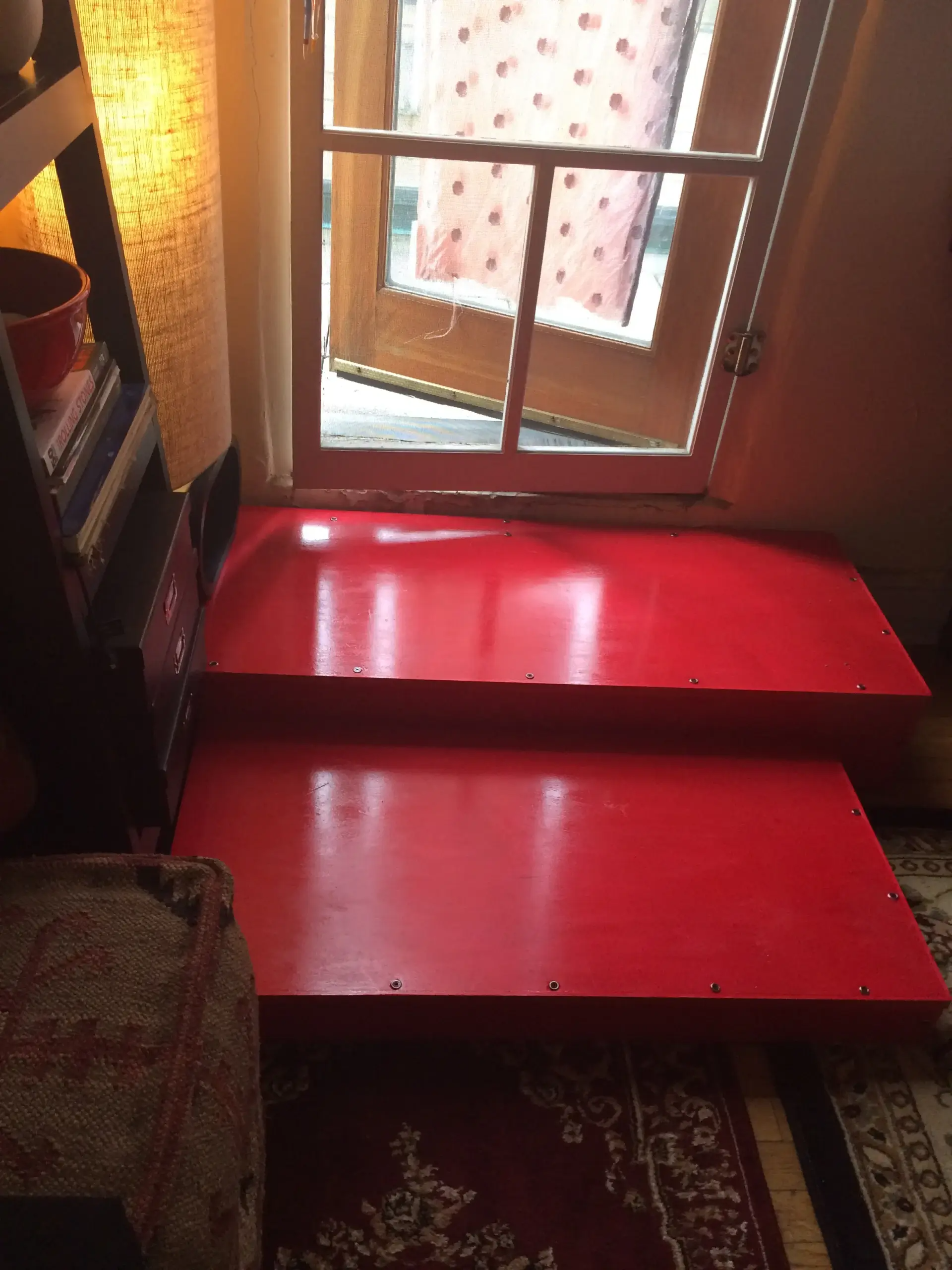 A red staircase with a window in the background