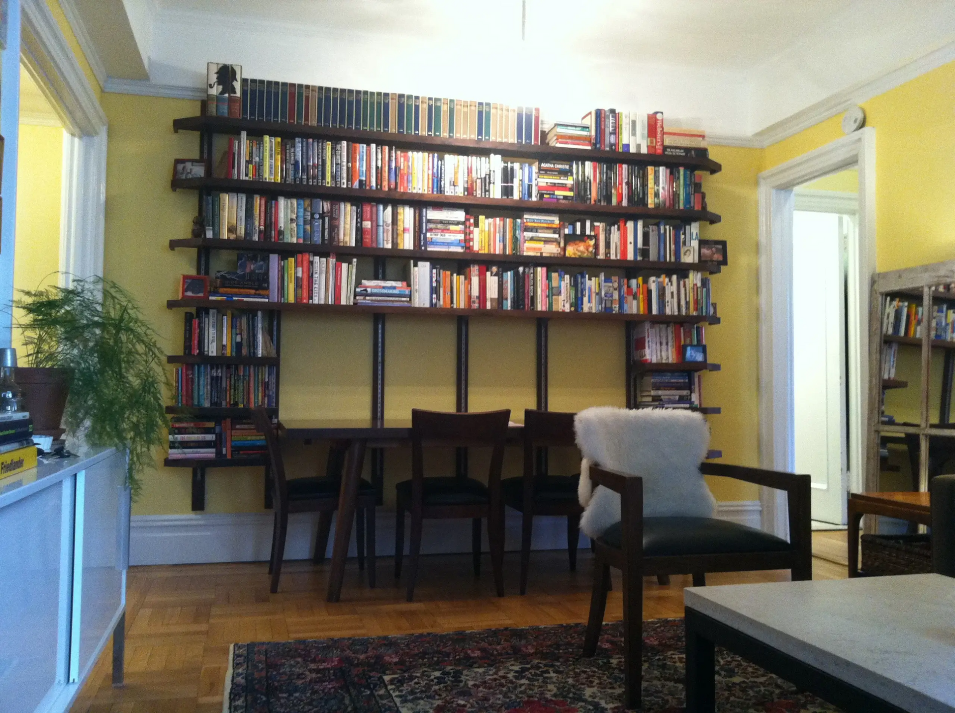 A living room with bookshelves and a table and chairs