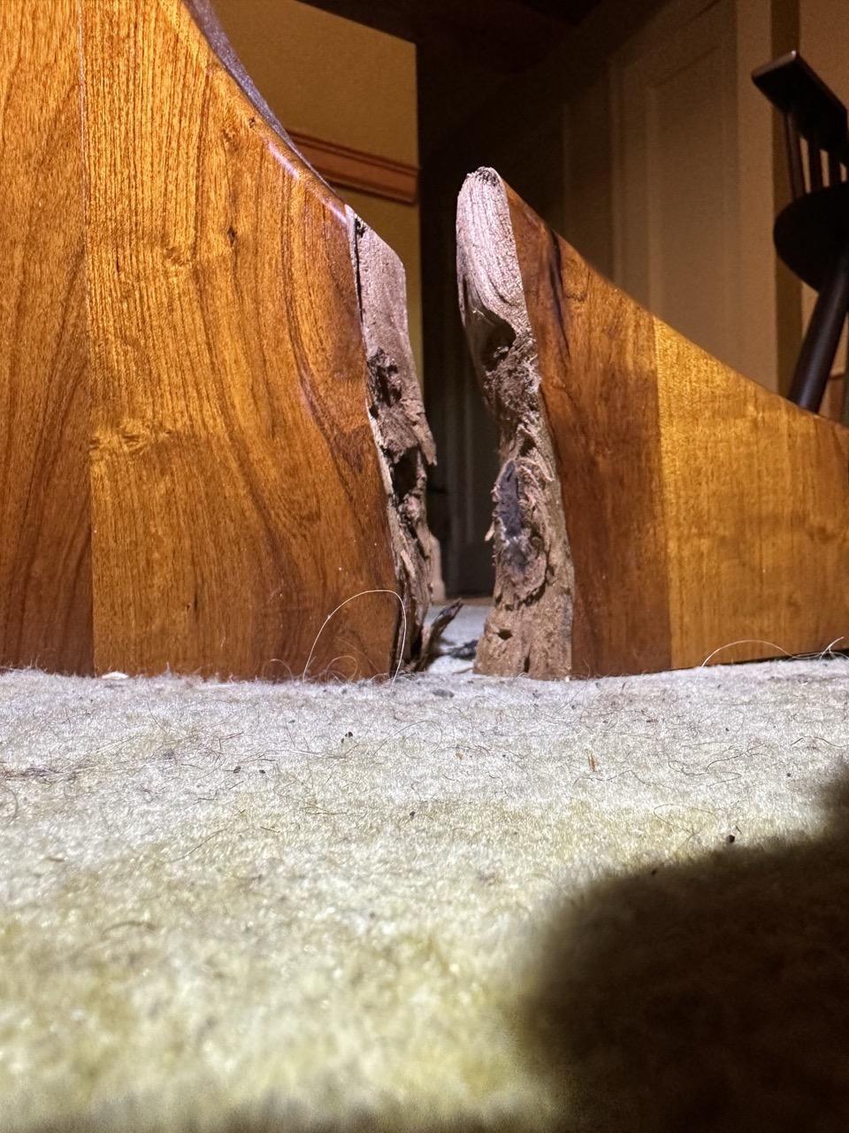 A piece of wood with a hole in it is sitting on a carpet.