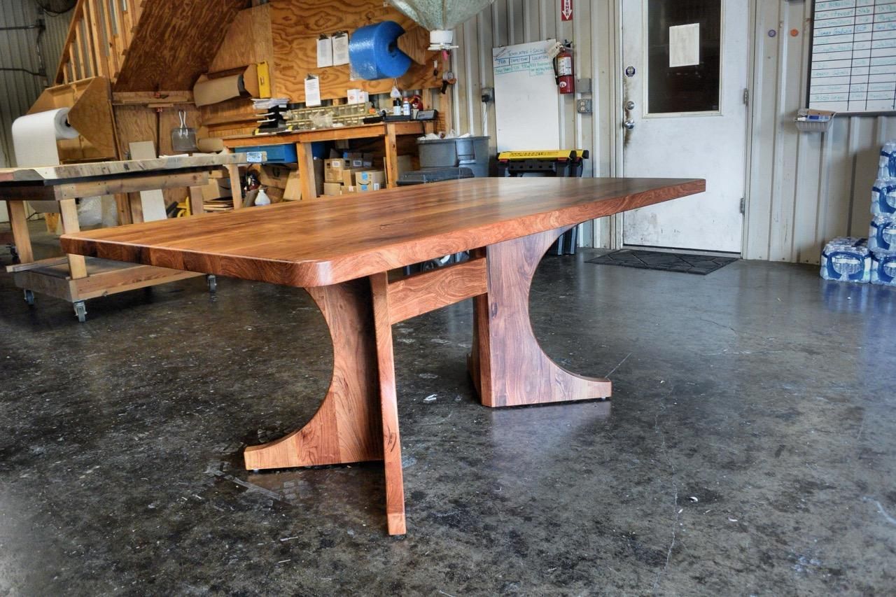 A wooden table is sitting on a concrete floor in a room.