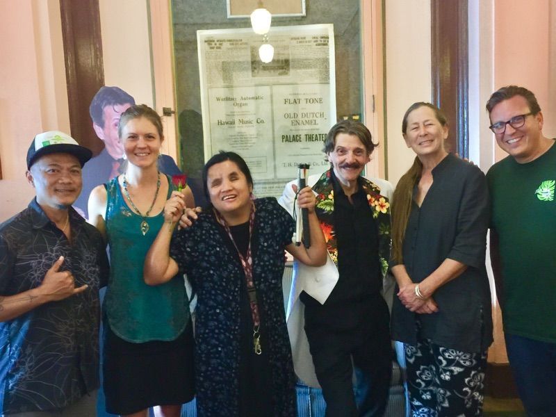 A group of people are posing for a picture in front of a sign that says