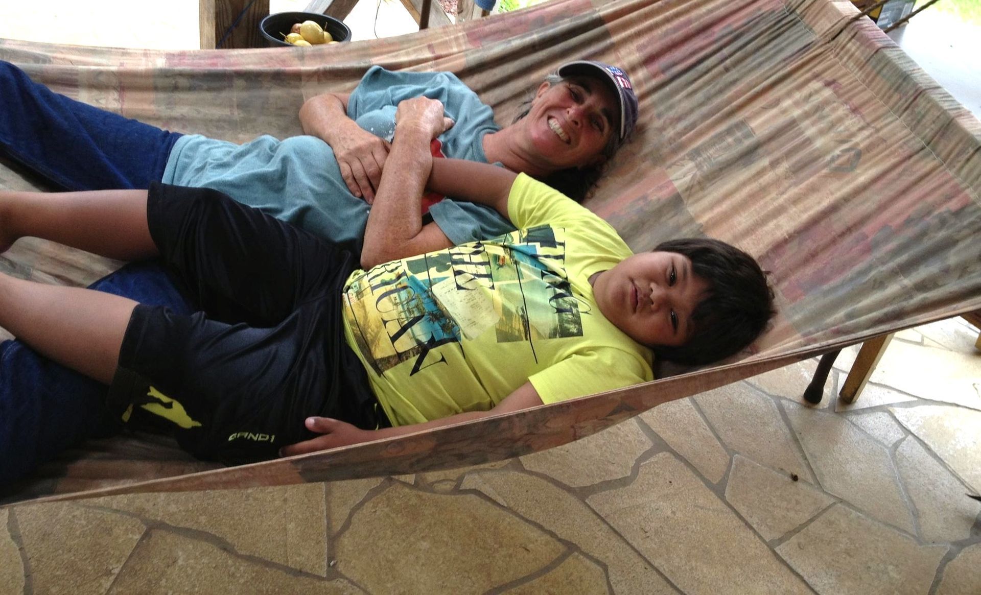 A man and a boy are laying in a hammock