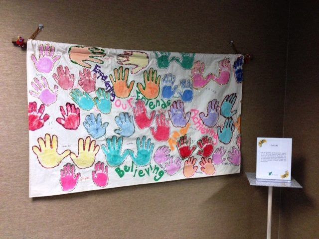 A painting of hands with the word believing on it