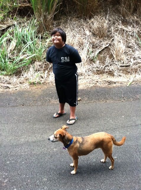 A boy standing next to a dog wearing a shirt that says s.u.