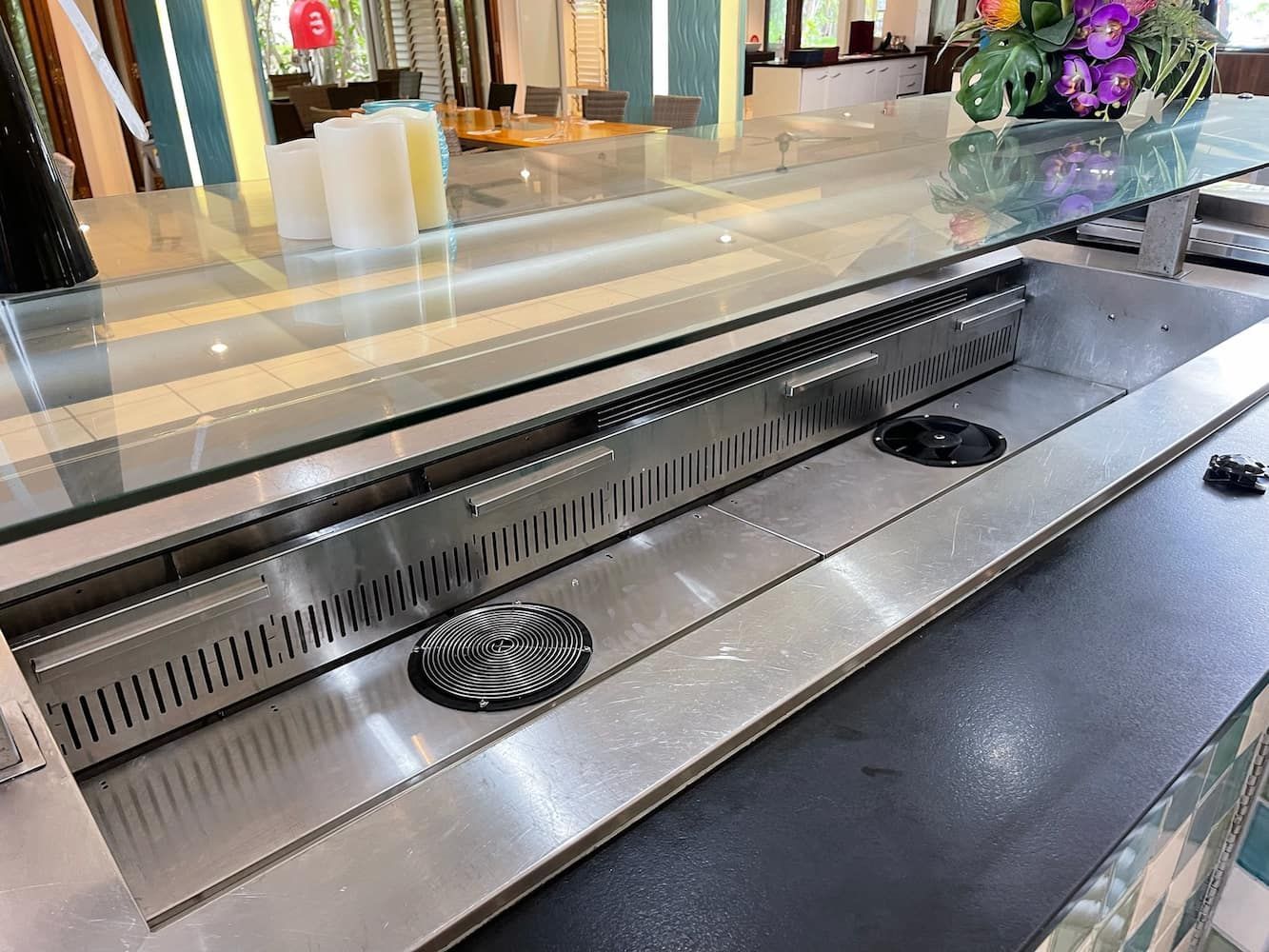 A Stainless Steel Counter With A Glass Top In A Restaurant — Davey Service & Maintenance Qld In Clinton, QLD