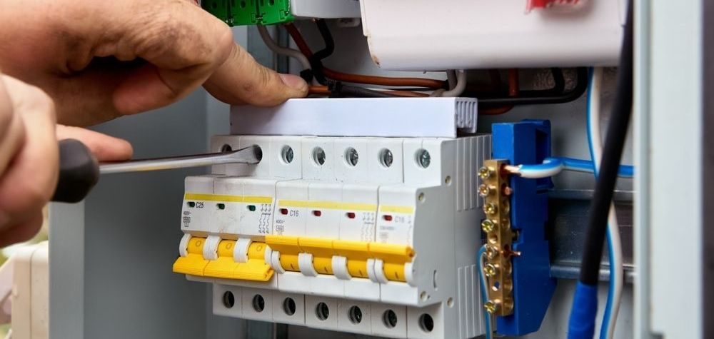 Electrician Using A Multimeter To Test Wires In A Control Panel — Davey Service & Maintenance Qld In Clinton, QLD