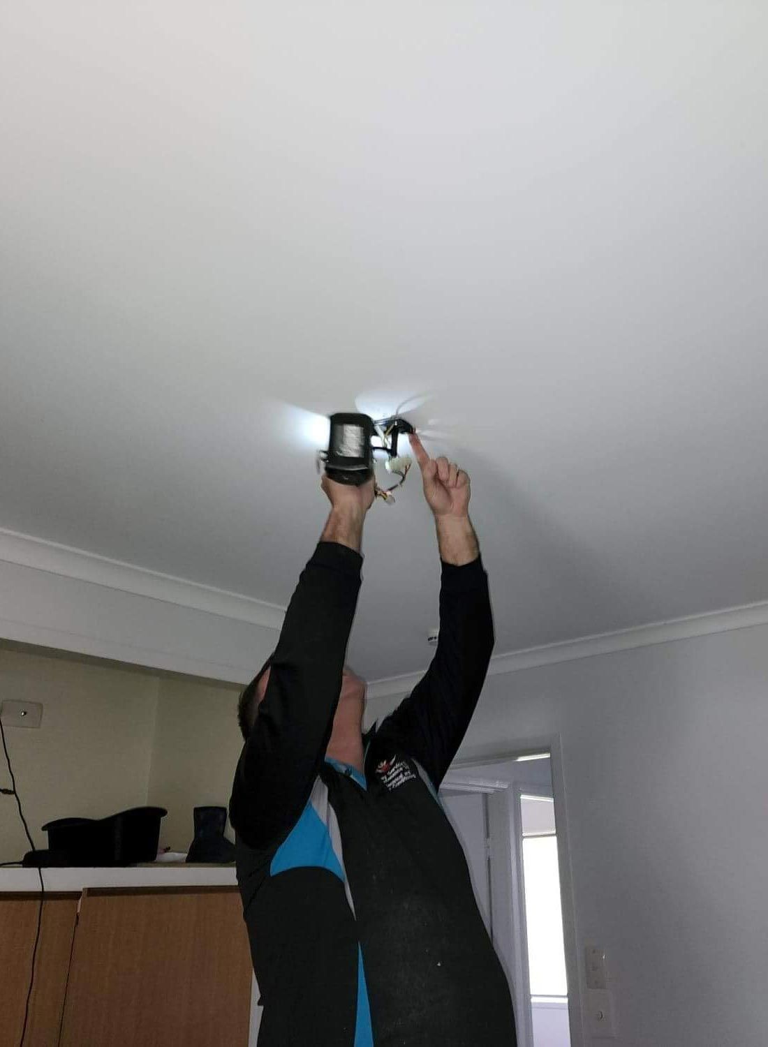 Electrician Drilling On Ceiling — Davey Service & Maintenance Qld In Clinton, QLD