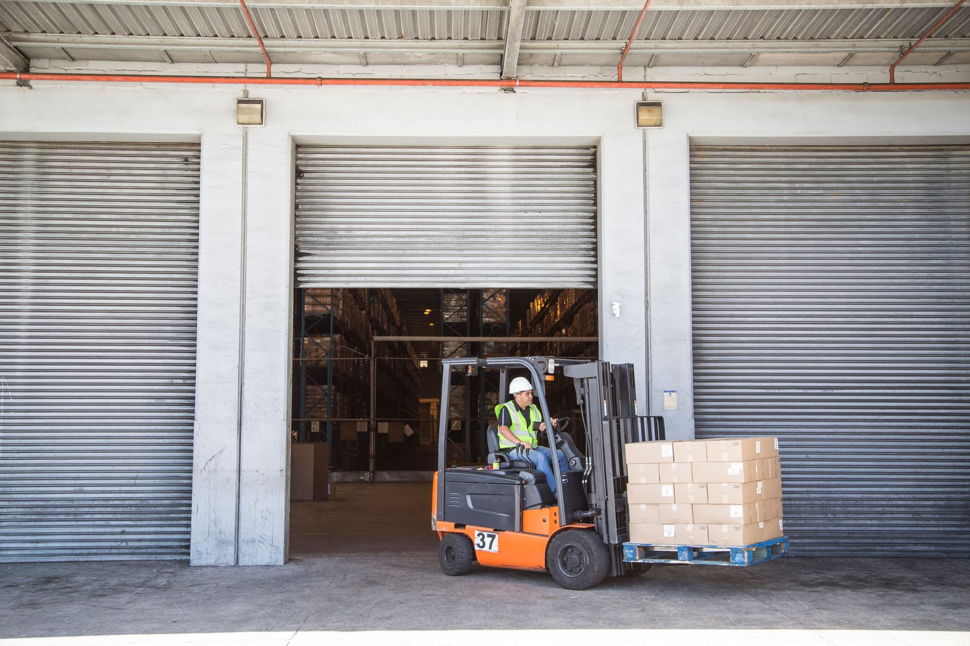 Forklift operator in warehouse with a load of boxes. Forklift operator in warehouse with a load of boxes.