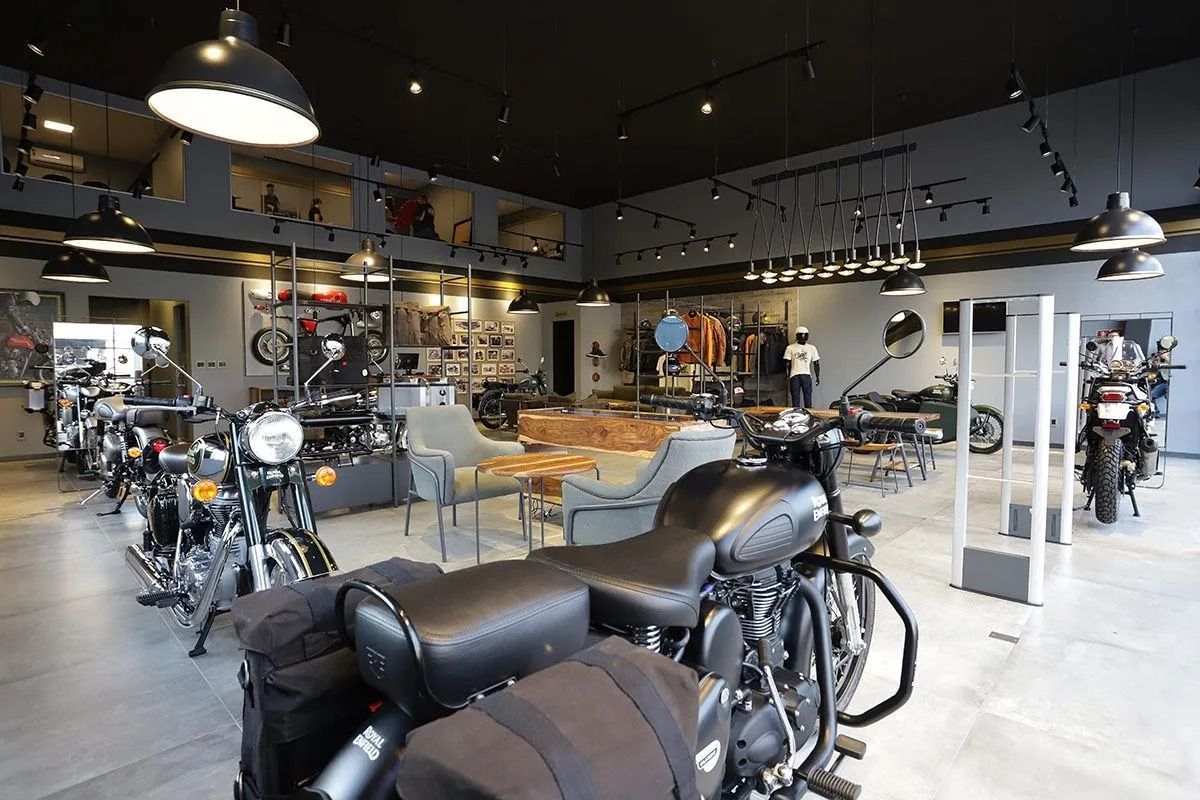 Showroom de motocicletas com várias motos expostas em um espaço de vendas moderno e iluminado.