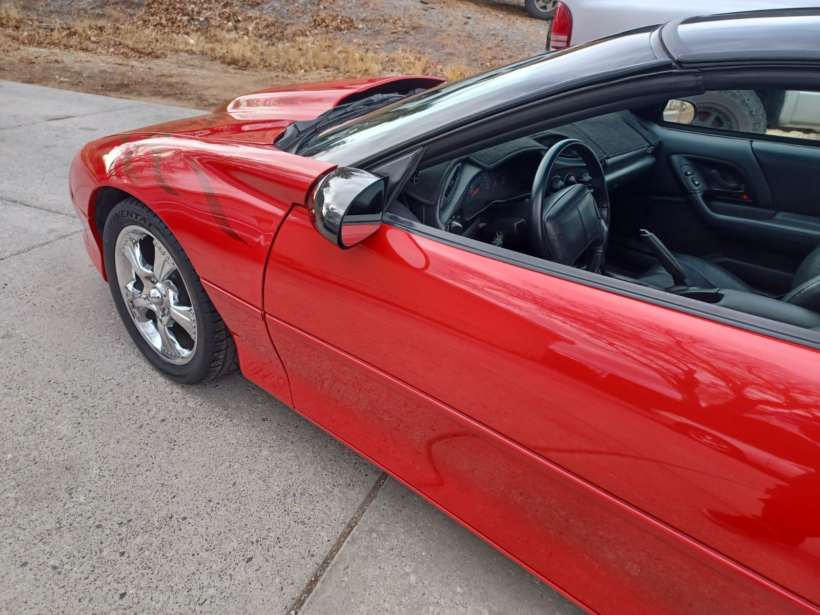 A red sports car is parked on the side of the road.
