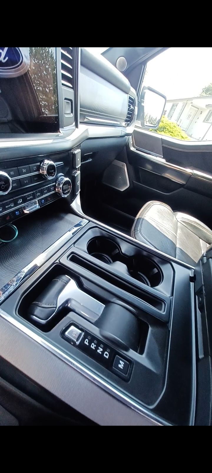 A close up of the interior of a car with a cup holder.