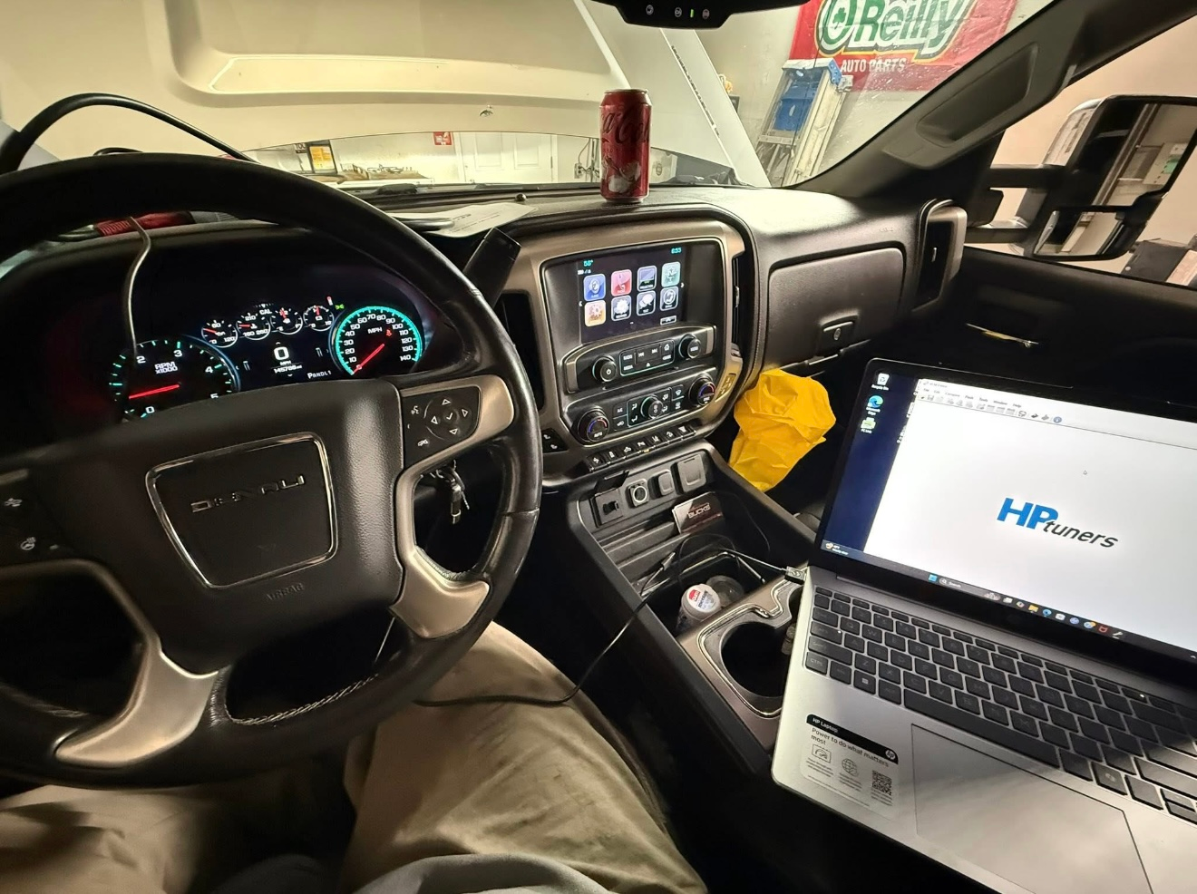 Interior of a truck with a laptop running HP Tuners software connected to the vehicle's diagnostic port.  | Bucks Auto Garage & Tire