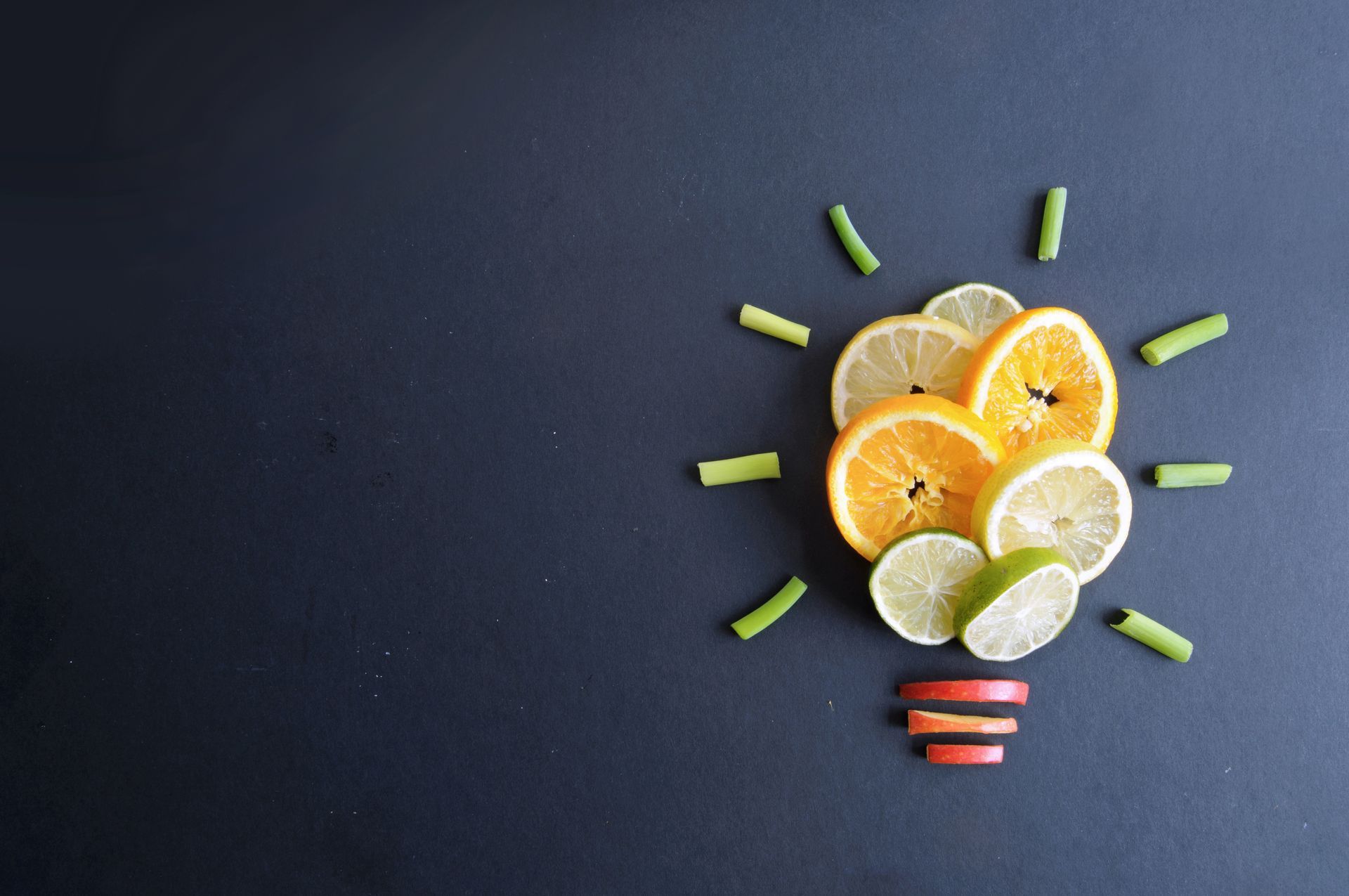 Sliced citrus fruits arranged as a lightbulb, with green bean