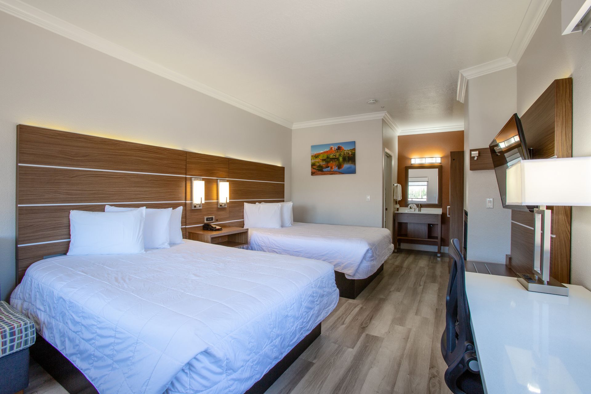 Inviting bedroom setup with two queen Beautyrest beds and fireplace at Wildflower Inn Sedona