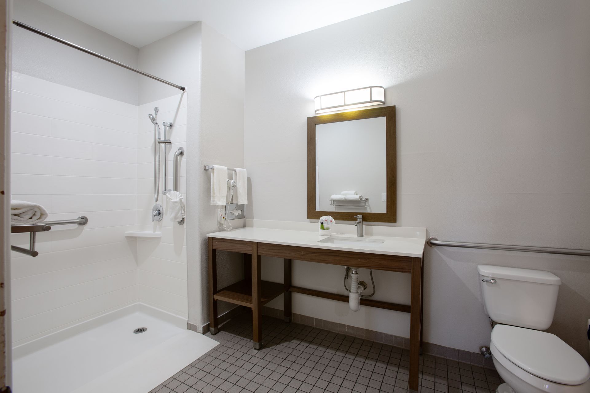Accessible bathroom with roll-in shower and support rails in King Accessible Room at Wildflower Inn