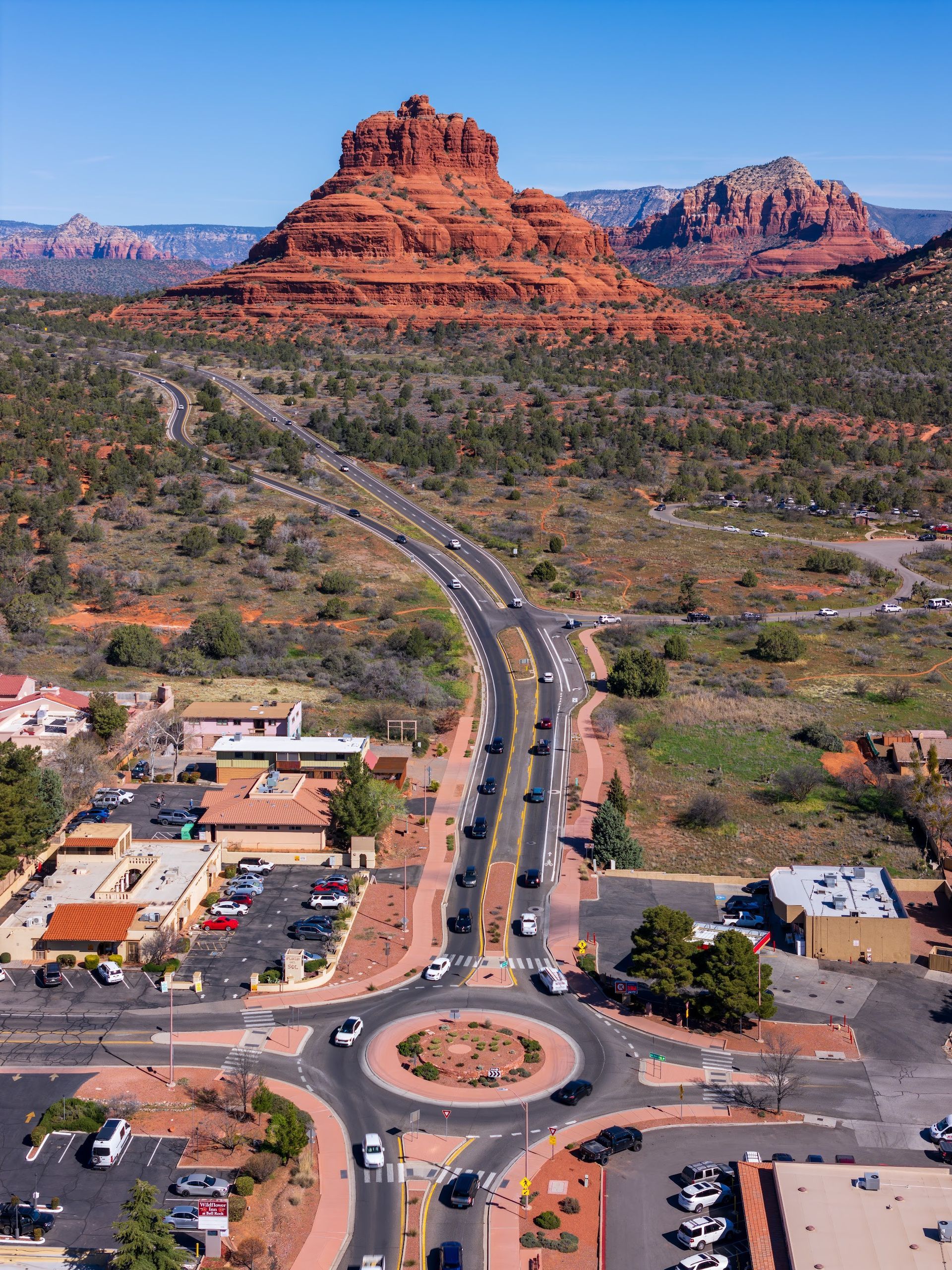 Aerial view of Bell Rock and Courthouse Butte rising above Highway 179 and Village of Oak Creek in Sedona Arizona
