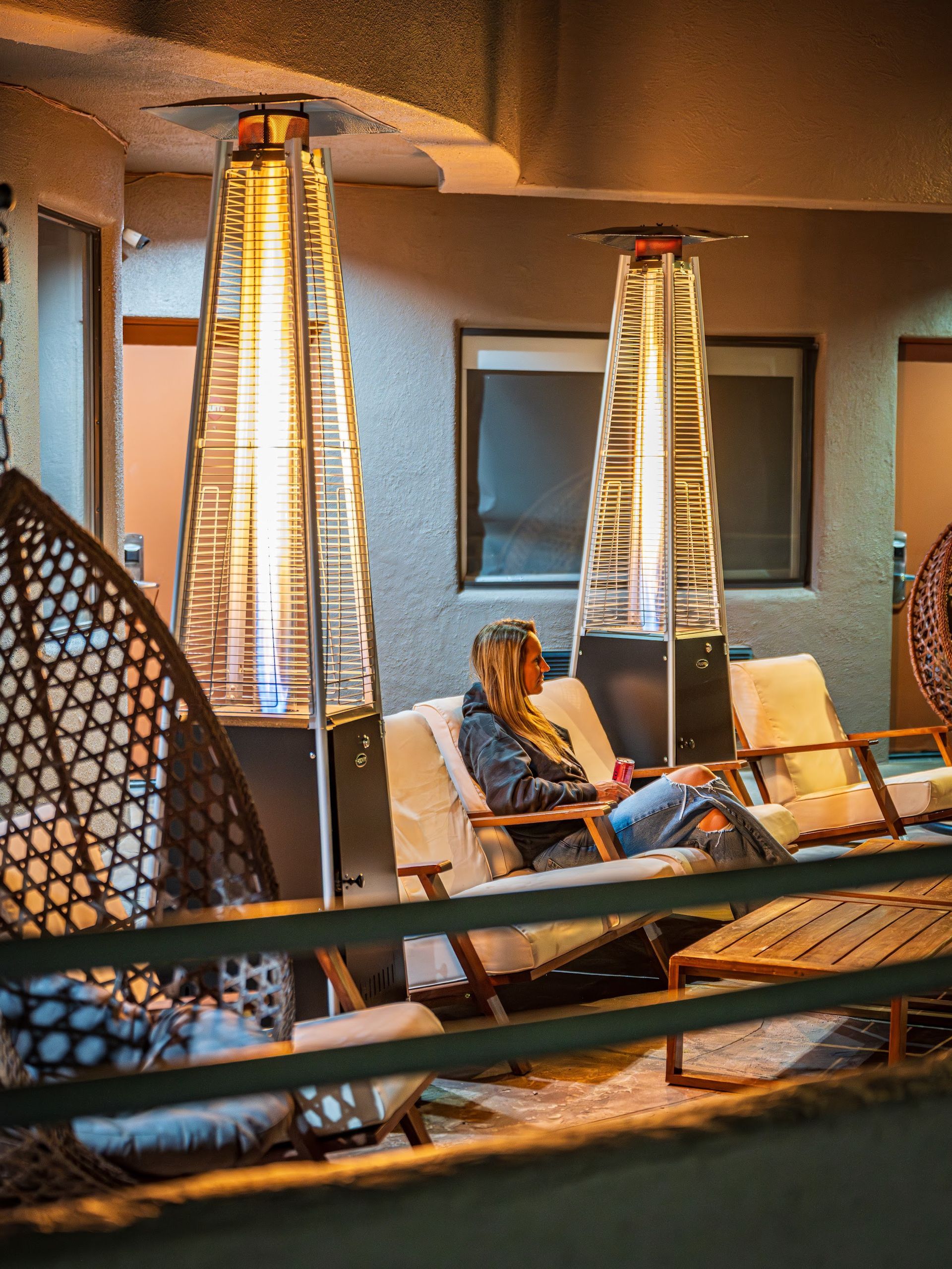 Guests relaxing under tall patio heat lamps on the outdoor terrace at Wildflower Inn at Bell Rock on a cool Sedona evening