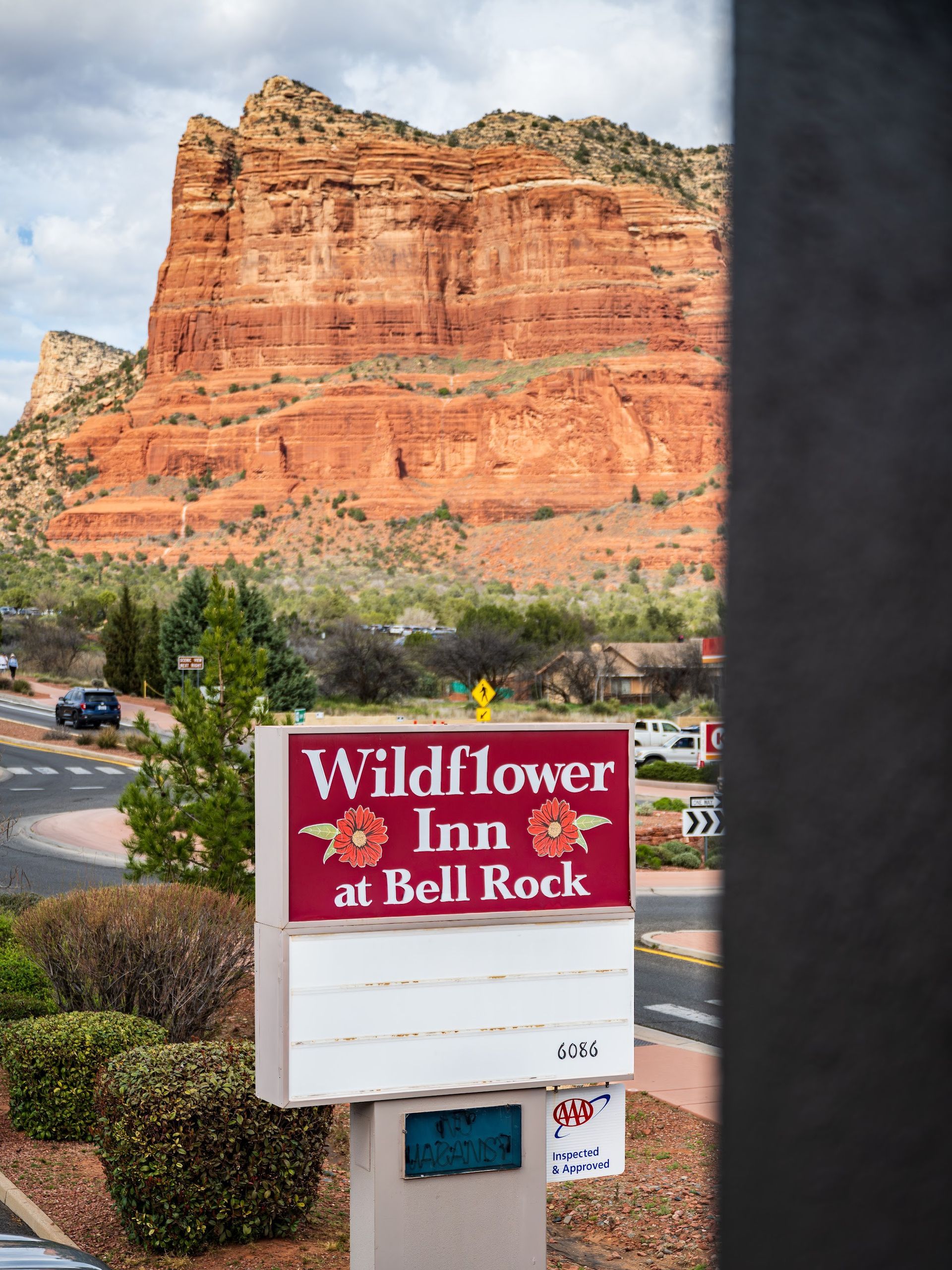 View of Courthouse Butte and the Wildflower Inn at Bell Rock sign framed by an open guest room doorway in Sedona Arizona