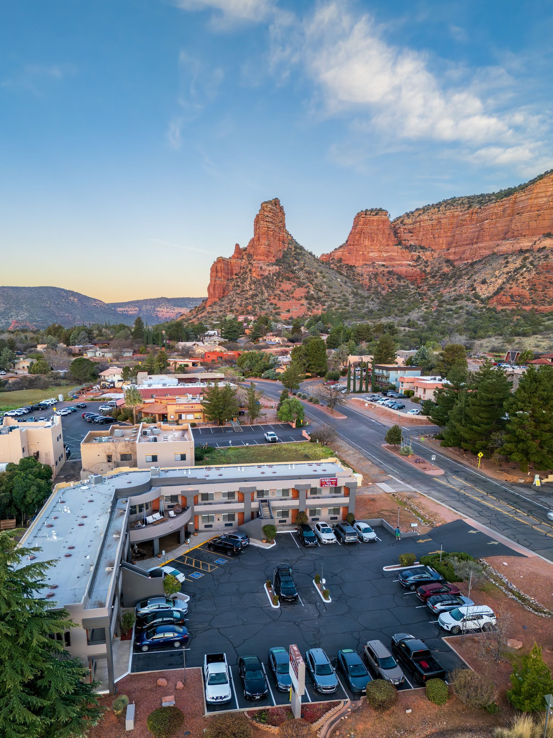Aerial view of Wildflower Inn at Bell Rock at dusk as Courthouse Butte glows above Village of Oak Creek in Sedona