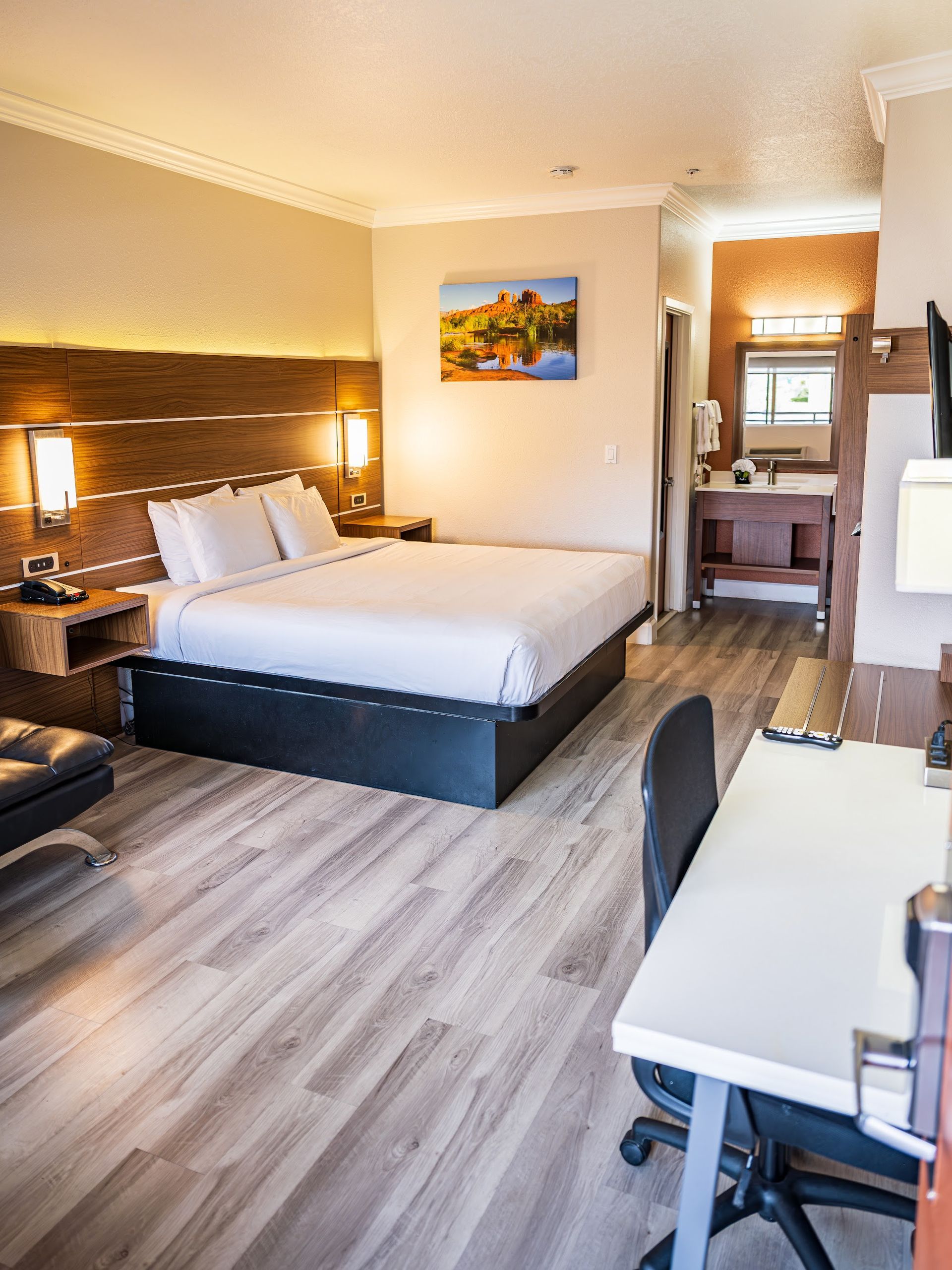 Guest room at Wildflower Inn at Bell Rock with a king bed, wood headboard and red rock artwork for an affordable Sedona stay
