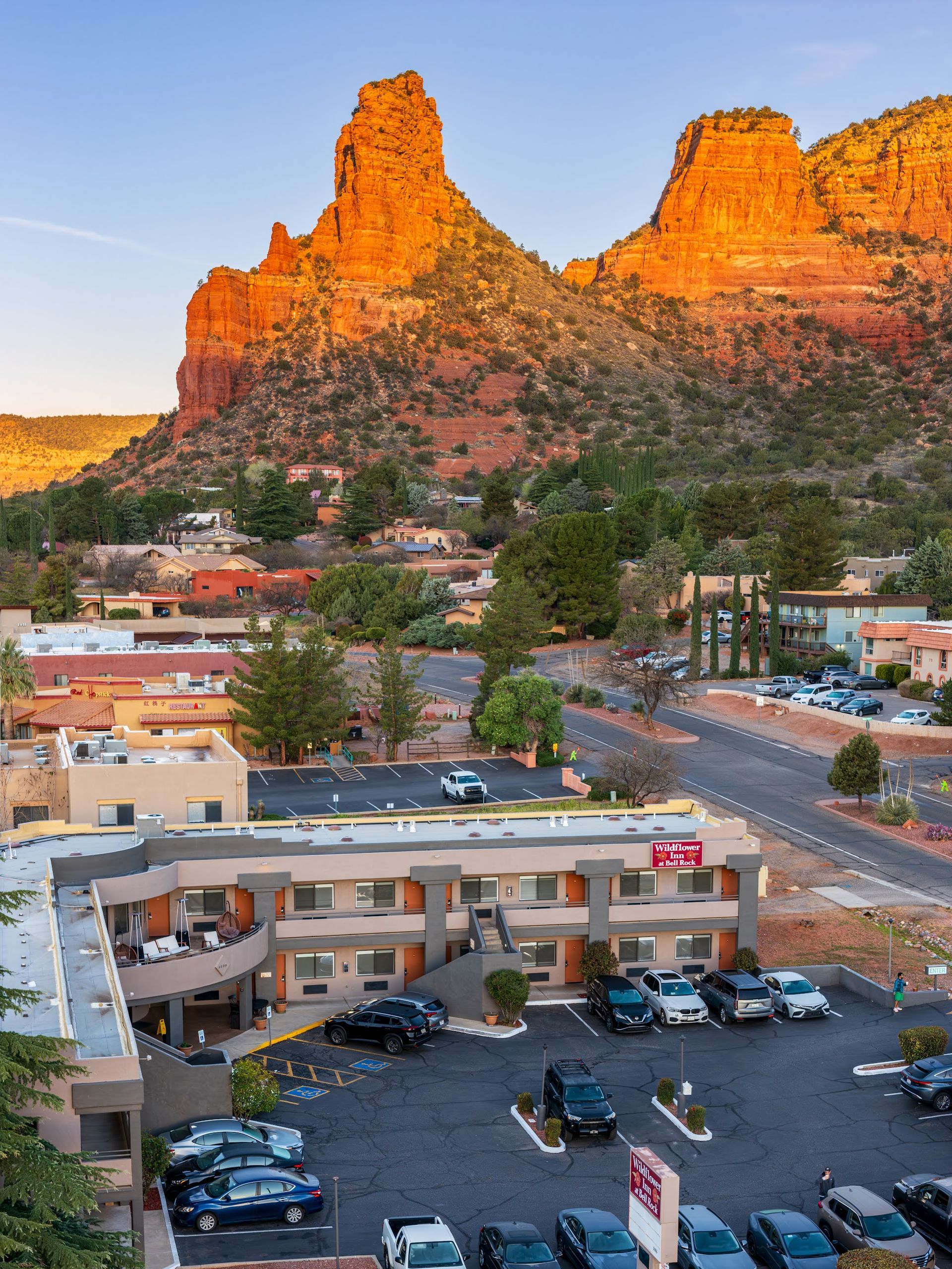 Courthouse Butte glowing at sunset above Wildflower Inn at Bell Rock and Village of Oak Creek in Sedona Arizona