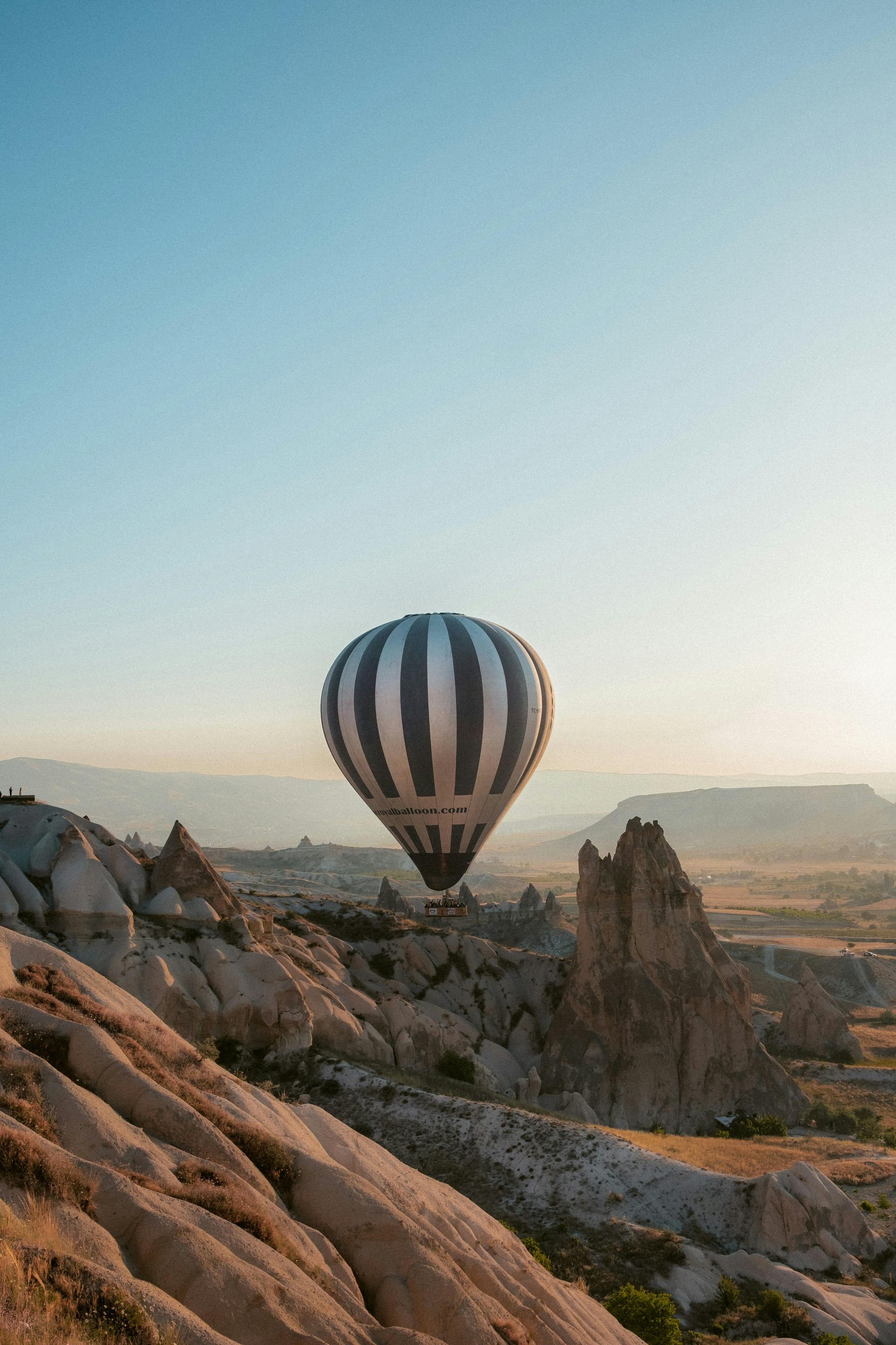 A hot air balloon is flying over a rocky landscape.