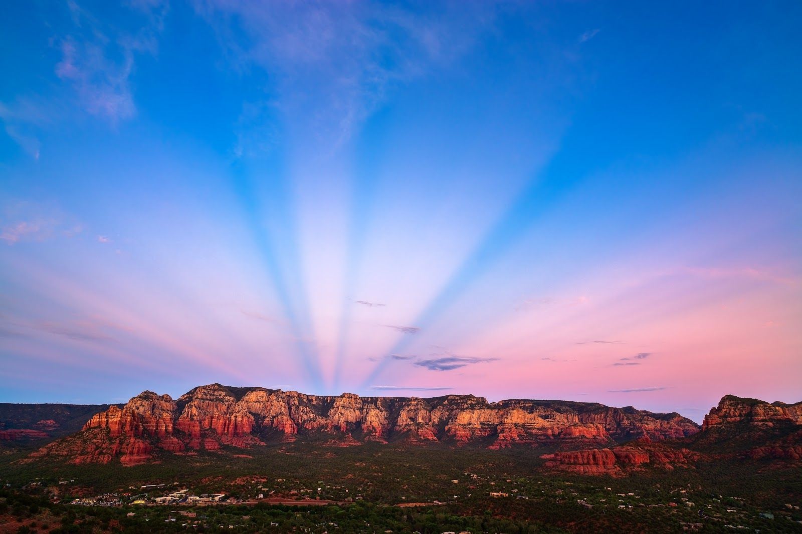Light rays fanning across the dusk sky over Sedona red rocks
