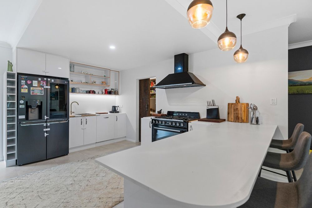 A Kitchen with White Cabinets, a Stove , a Refrigerator and A Bar — Cairns Vacate Clean in Manunda, QLD
