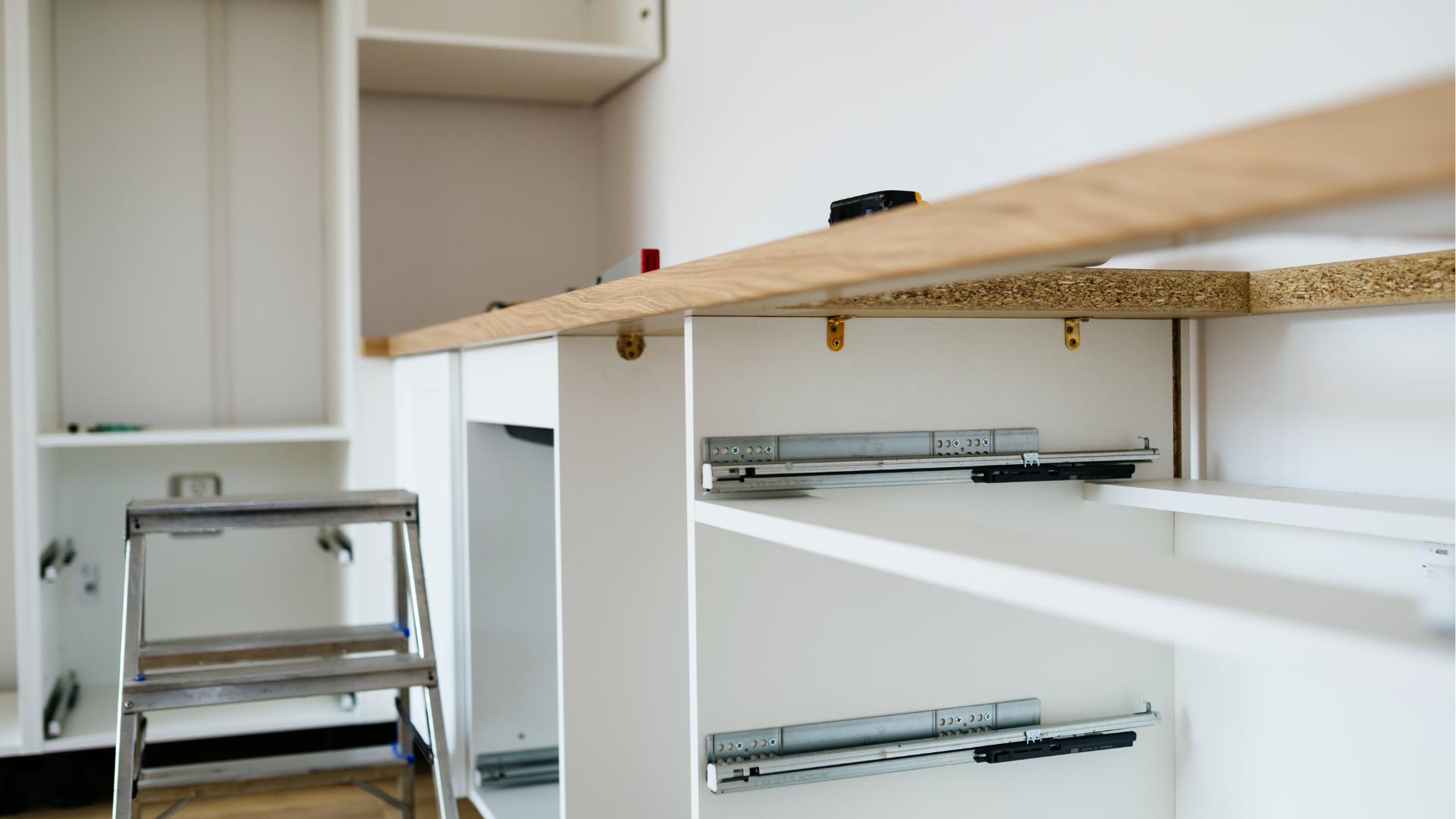 Kitchen cabinet drawer slides installed under a wooden countertop