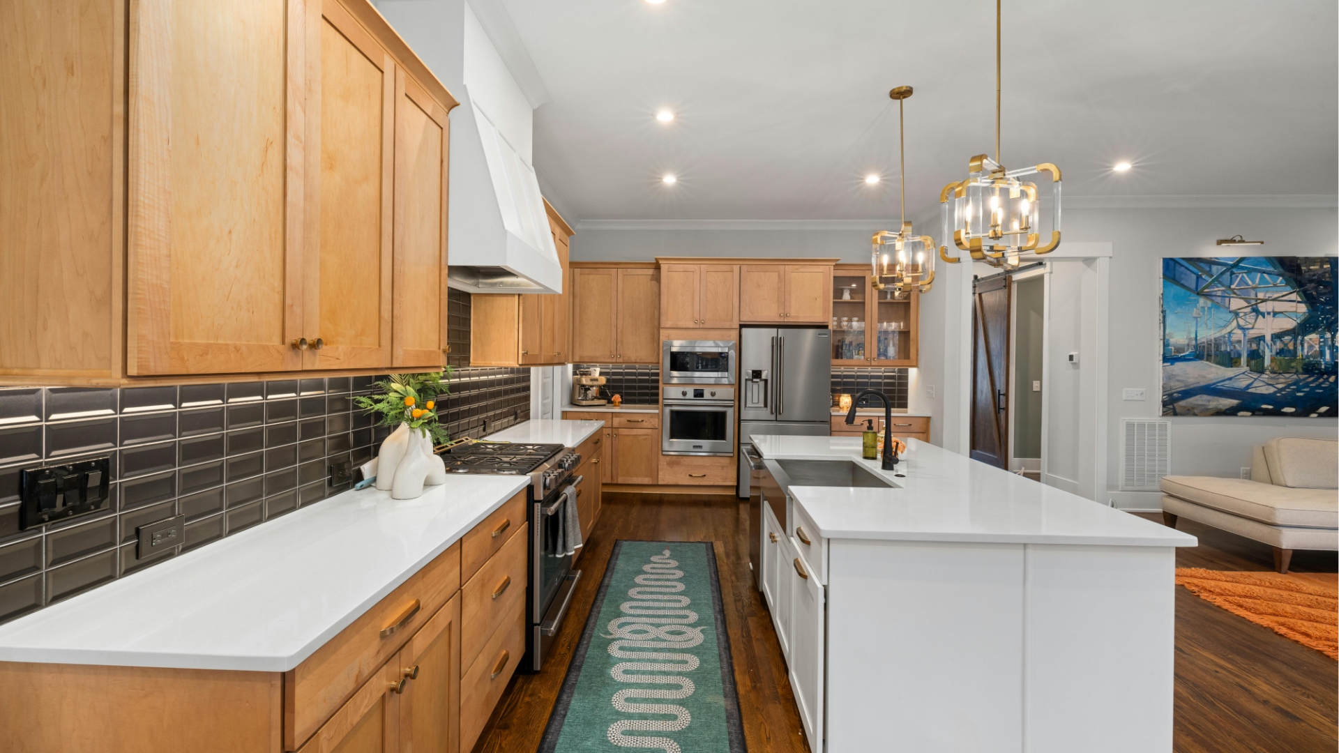 Bright modern kitchen with wood cabinets, white island, stainless appliances, and dining area in back