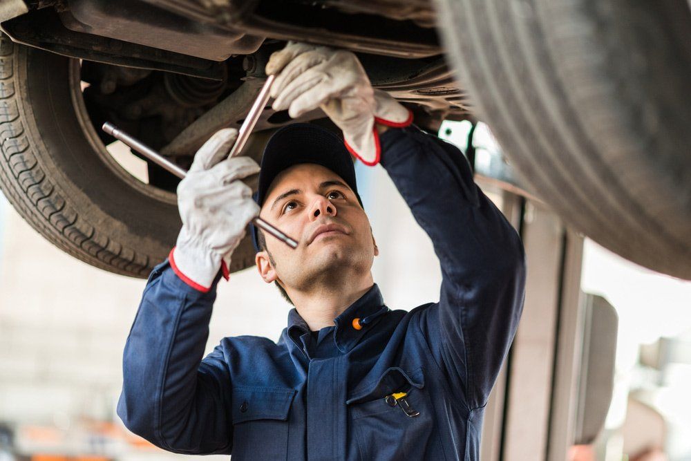 Mechanic Repairing a Lifted Car — Roadworthy Certificates in West Gosford NSW