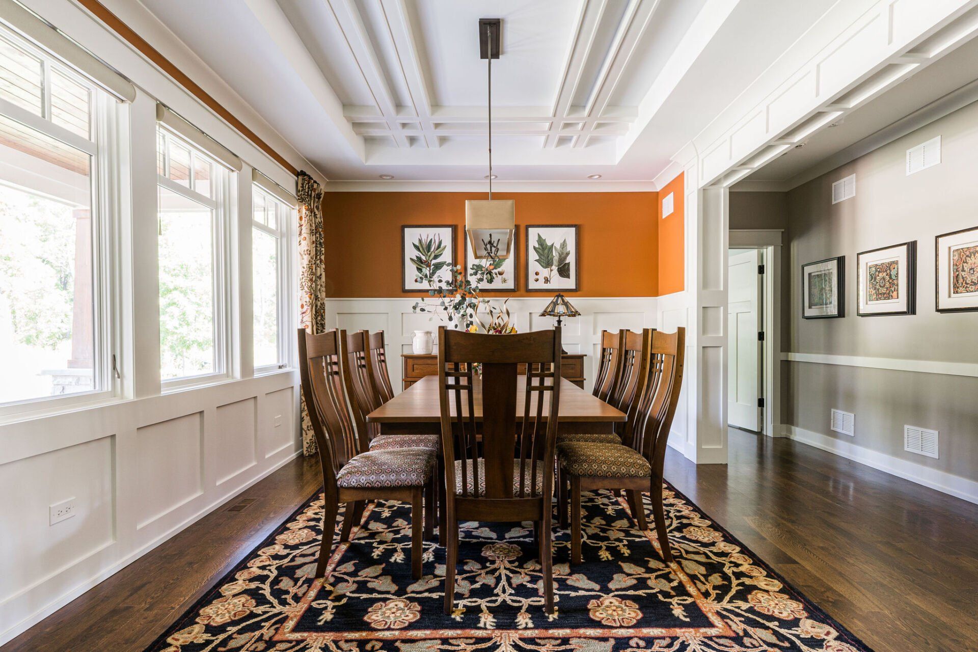 A dining room with a table and chairs and a rug.