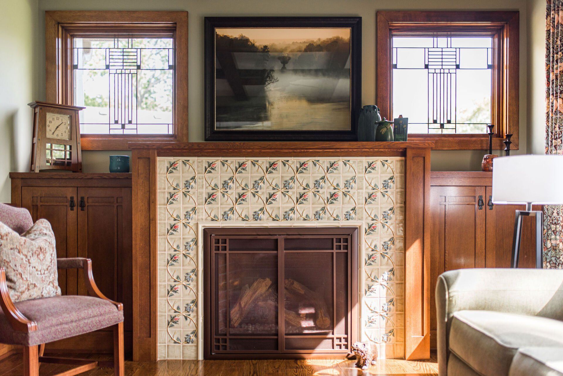 A living room with a fireplace and a painting on the wall.