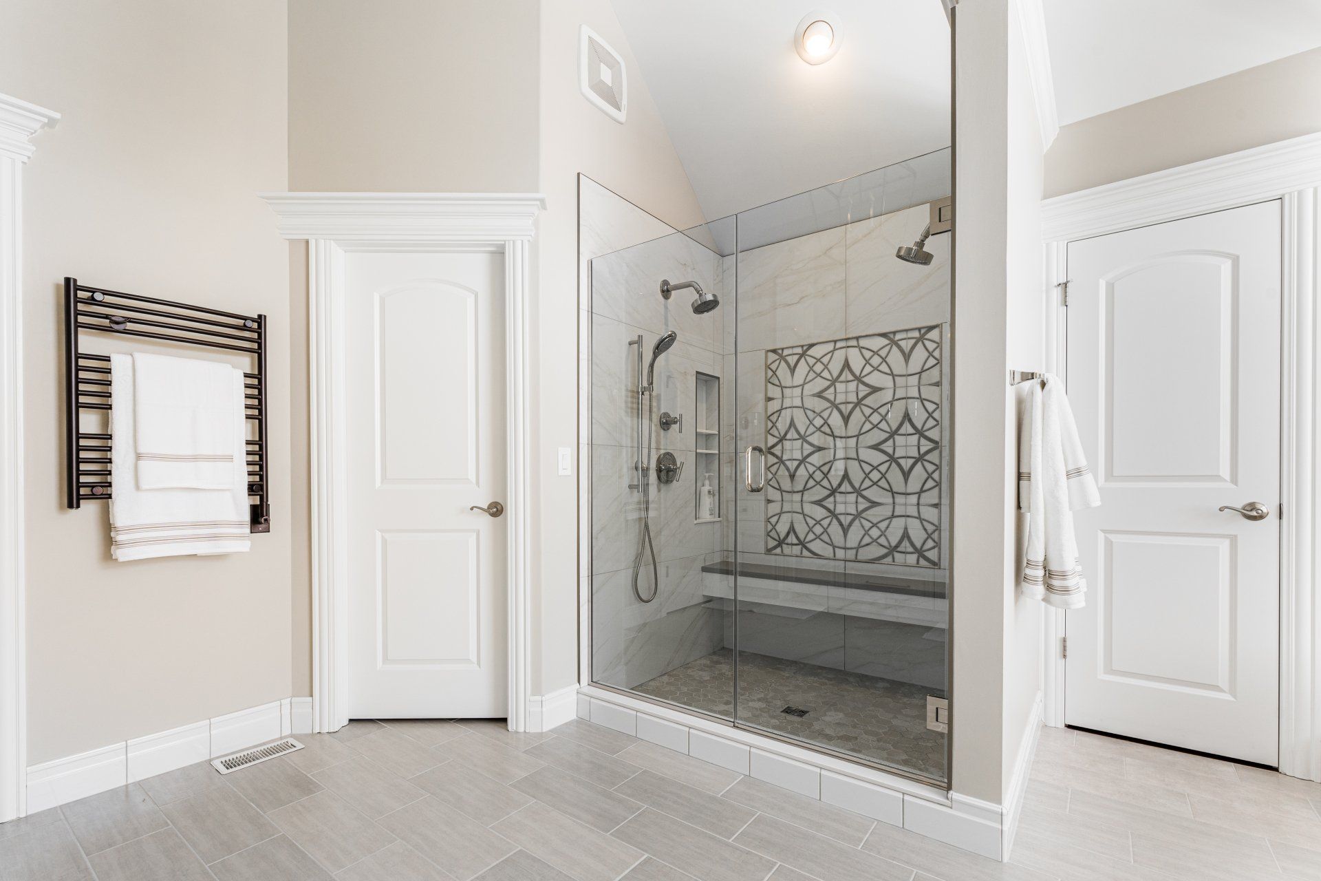 A bathroom with a walk in shower and a bench.