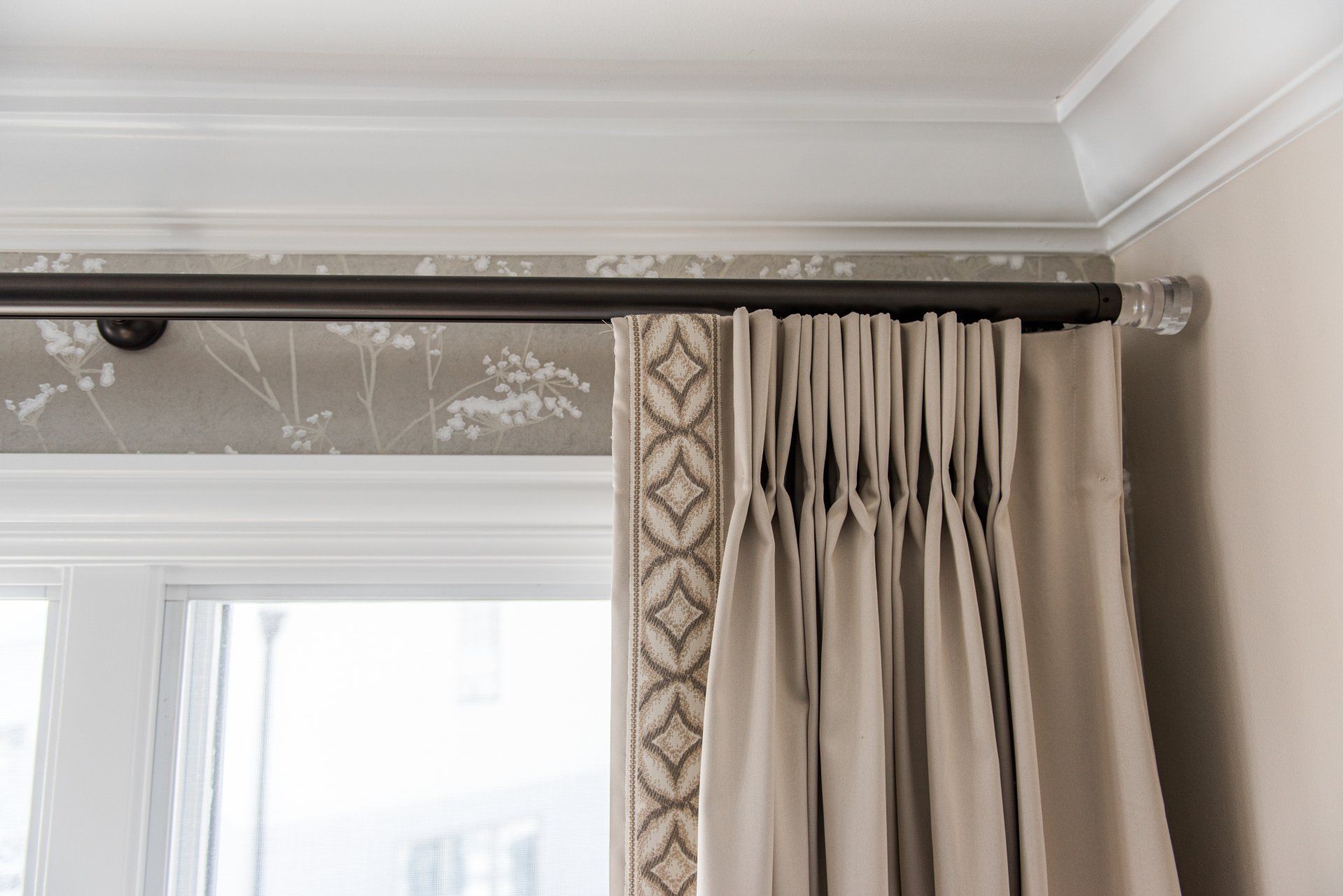 A close up of a pair of curtains hanging on a window.