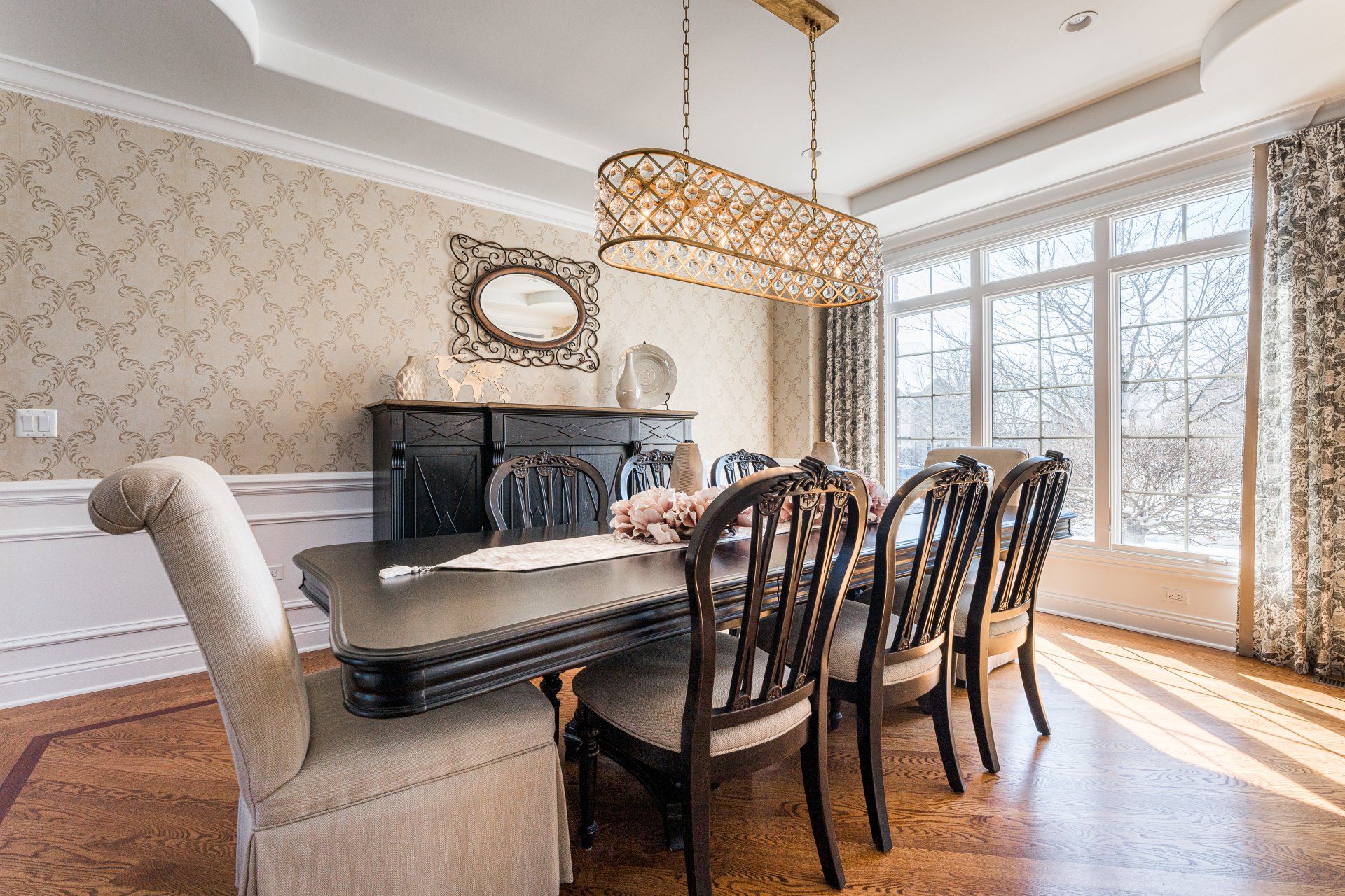 A dining room with a table and chairs and a chandelier.