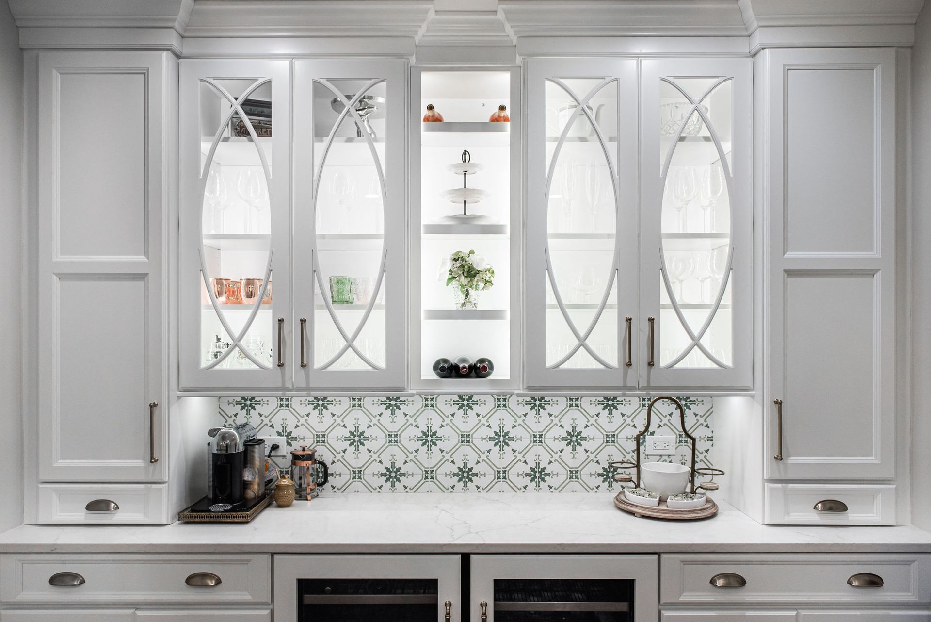 A kitchen with white cabinets , a sink , and a refrigerator.